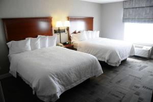雷丁雷丁汉普顿套房酒店的酒店客房内的两张床,配有白色床单