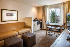 本德本德希尔顿逸林酒店的酒店客房设有沙发、桌子和厨房。