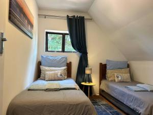 爱德华港Big Fish Seaside Cottage, Sleeps 10 Guests in 5 Bedrooms的一间卧室设有两张床和窗户。