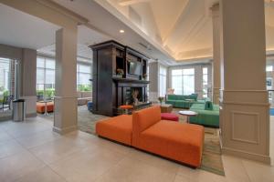 达拉姆达勒姆梭斯波恩特希尔顿花园酒店的客厅配有橙色椅子和壁炉