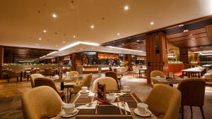 沙马林达FUGO Hotel Samarinda的一间带桌椅的餐厅和一间酒吧
