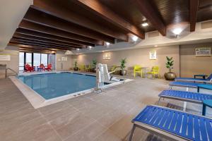 迪卡尔布Home2 Suites By Hilton DeKalb的一座大型游泳池,里面设有蓝色长椅