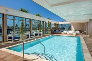 圣地亚哥圣地亚哥市中心/碧沙希尔顿惠庭套房酒店的一座带玻璃窗的建筑中的游泳池