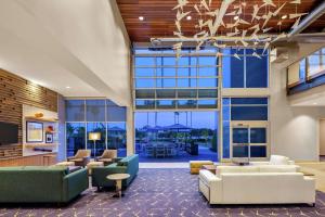 圣地亚哥Hampton Inn & Suites San Diego Airport Liberty Station的带沙发、椅子和窗户的办公大堂
