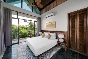 宁平Coco Island Villa & Hotel Ninh Bình的卧室设有白色的床和大窗户