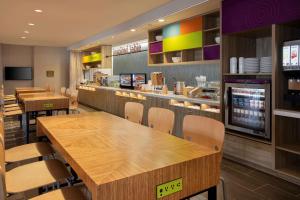 刘易斯Home2 Suites By Hilton Lewes Rehoboth Beach的一间设有木桌和椅子的快餐店