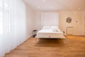 索里亚DWO Ábaster Suites的白色墙壁和木地板的客房内的一张床位