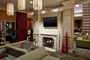 斯科茨斯科特斯德古镇希尔顿花园酒店的客厅设有壁炉和电视。