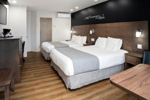 拉图克Hôtel Marineau La Tuque的酒店客房设有两张床和一张桌子。