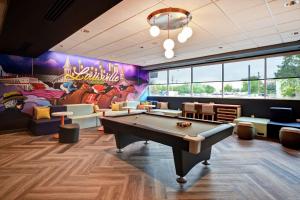 路易斯威尔Tru By Hilton Louisville Airport的一间带台球桌和壁画的房间