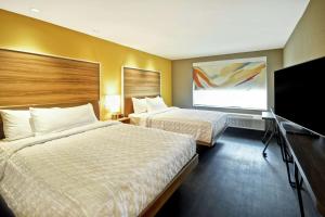 路易斯威尔Tru By Hilton Louisville Airport的酒店客房设有两张床和一台平面电视。