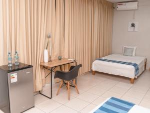 普卡尔帕Leveint Executive Hotel的酒店客房配有一张床和一张带椅子的书桌