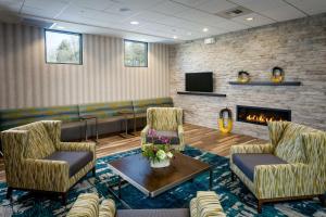 西雅图希尔顿西雅图/北门汉普顿套房酒店的一间设有两把椅子和壁炉的等候室