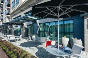 西雅图希尔顿西雅图/北门汉普顿套房酒店的一个带桌椅和遮阳伞的庭院