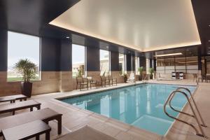 南乔丹南约旦盐湖城希尔顿大使馆套房酒店 的一座配有桌椅的酒店游泳池