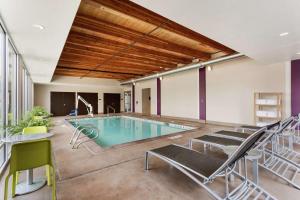 穆雷盐湖城穆雷UT希尔顿欣庭套房酒店的一个带椅子和桌子的房间的游泳池