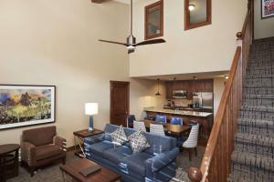 帕克城Hilton Grand Vacations Club Sunrise Lodge Park City的一间带蓝色沙发的客厅和一间厨房