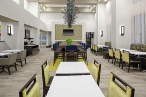 尔湾汉普顿尔湾/橘郡机场酒店的一间带桌椅和电视的用餐室
