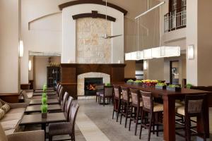 圣马科斯圣马科斯汉普顿套房酒店的一间带壁炉和桌椅的用餐室