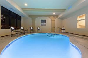 圣克鲁兹圣克鲁兹欢朋酒店的一个带椅子和桌子的房间的游泳池