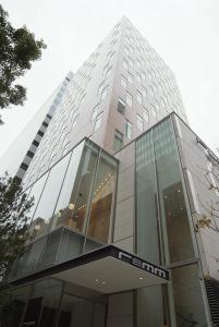 东京remm Hibiya的一座高大的玻璃建筑,上面有标志
