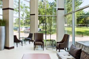 布里奇顿Embassy Suites by Hilton St Louis Airport的大堂设有桌椅和窗户。