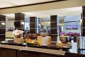 布里奇顿Embassy Suites by Hilton St Louis Airport的餐厅在柜台上供应自助餐和碗
