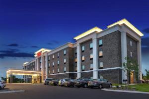 伍德伯里Hampton Inn & Suites Saint Paul Oakdale Woodbury的停车场内有车辆的旅馆