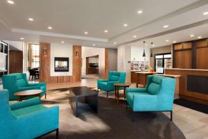 东叙拉古希尔顿雪城惠庭套房酒店 - 卡里尔环岛的一间设有蓝色椅子和桌子的等候室