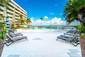 坦帕DoubleTree by Hilton Tampa Rocky Point Waterfront的游泳池旁的一排长椅