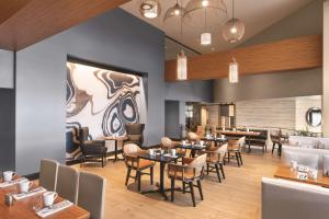 坦帕DoubleTree by Hilton Tampa Rocky Point Waterfront的一间带桌椅的餐厅和一间酒吧