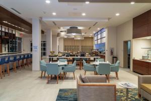 卫斯理堂Hilton Garden Inn Tampa - Wesley Chapel的一间带桌椅的餐厅和一间酒吧