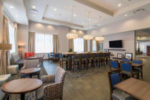 塔尔萨Hampton Inn & Suites Tulsa Downtown, Ok的酒店客房设有桌椅和酒吧