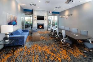 卡图萨Homewood Suites By Hilton Tulsa Catoosa的客厅设有蓝色的沙发、桌子和壁炉
