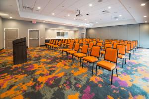 卡图萨Homewood Suites By Hilton Tulsa Catoosa的一间会议室,配有橙色椅子和讲台