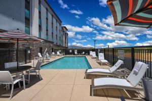土桑Hampton Inn Suites Tucson Tech Park的酒店游泳池设有椅子和遮阳伞