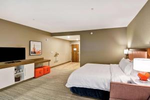 土桑Hampton Inn Suites Tucson Tech Park的配有一张床和一台平面电视的酒店客房