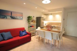 比比翁维拉吉奥马雷卢布公寓式酒店的客厅配有红色的沙发、桌子和椅子