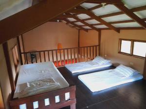 安蒂波洛Antipolo Cabin Getaway的一间设有两张床的客房,位于一个楼梯的房间