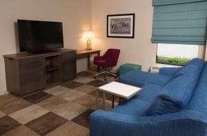 伍斯特伍斯特汉普顿酒店的客厅配有蓝色的沙发和电视