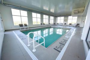 特鲁罗NS特鲁罗汉普顿套房酒店的大楼内带桌椅的大型游泳池