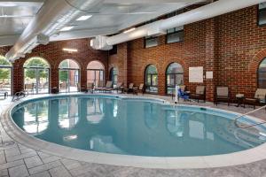 威廉斯堡威廉斯堡大使馆套房酒店的一座砖墙建筑中的一个大型游泳池
