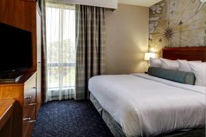 威廉斯堡威廉斯堡大使馆套房酒店的配有一张床和一台平面电视的酒店客房