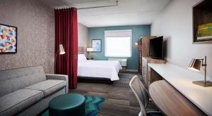 布兰特福德Home2 Suites By Hilton Brantford的酒店客房,配有床和沙发