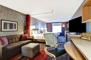 埃德蒙顿Home2 Suites By Hilton Edmonton South的酒店客房,配有床和沙发