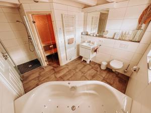 诺德霍恩ViLLA WASSERSTADT的白色的浴室设有浴缸和水槽。