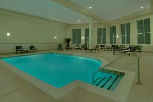 渥太华渥太华机场希尔顿花园酒店的一座带桌椅的大型游泳池