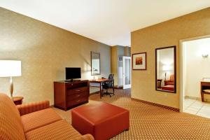 渥太华渥太华机场希尔顿花园酒店的客厅配有沙发和书桌及电视