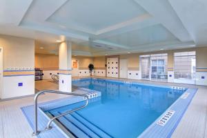 萨德伯里萨德伯里希尔顿惠庭套房酒店的大楼内一个蓝色的大型游泳池