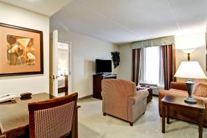 萨德伯里萨德伯里希尔顿惠庭套房酒店的一间带桌子和椅子的客厅和一间房间